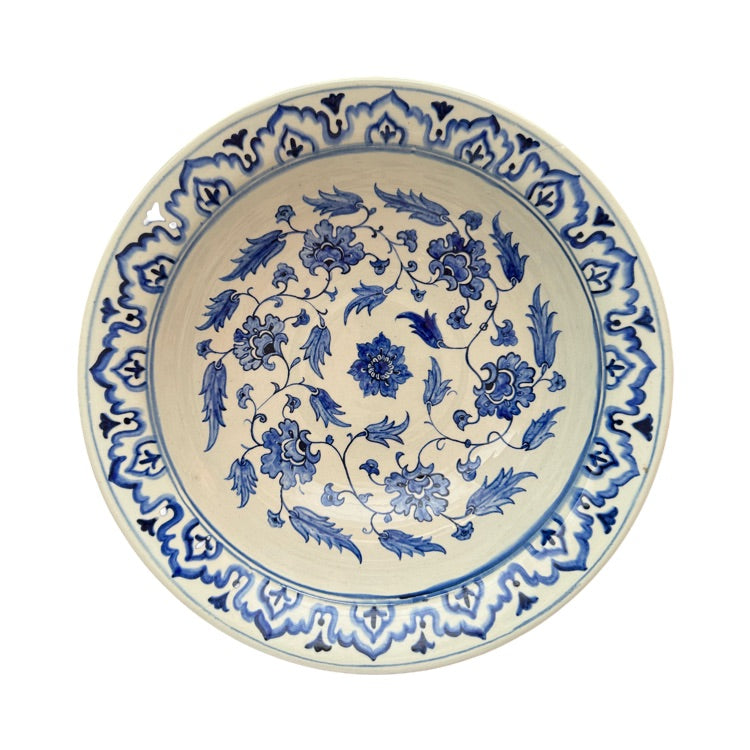 The Voyage Dubai - Hand-painted Iznik ceramic bowl by acclaimed Turkish artist Adil Can Güven. The bowl is painted in a traditional Iznik style featuring a blue and white floral design.