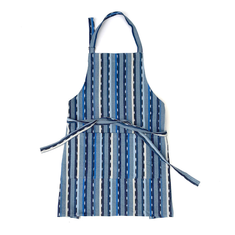 The Voyage Dubai - Handwoven Ikat Apron - Blue  Whether in the kitchen or the garden our ikat apron is up to the task!  Made from colourful and sturdy handwoven fabric and sewn with a double pocket to hold your tools and everything else you may need on hand. Comes with adjustable neck strap and waist ties long enough to tie in the front or back for a custom fit.  